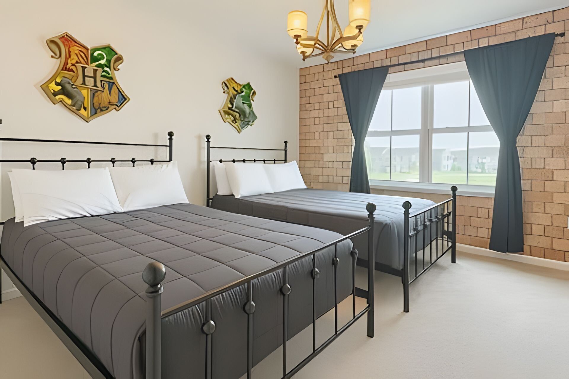 Een slaapkamer met twee bedden, een bakstenen muur en een raam met gordijnen.