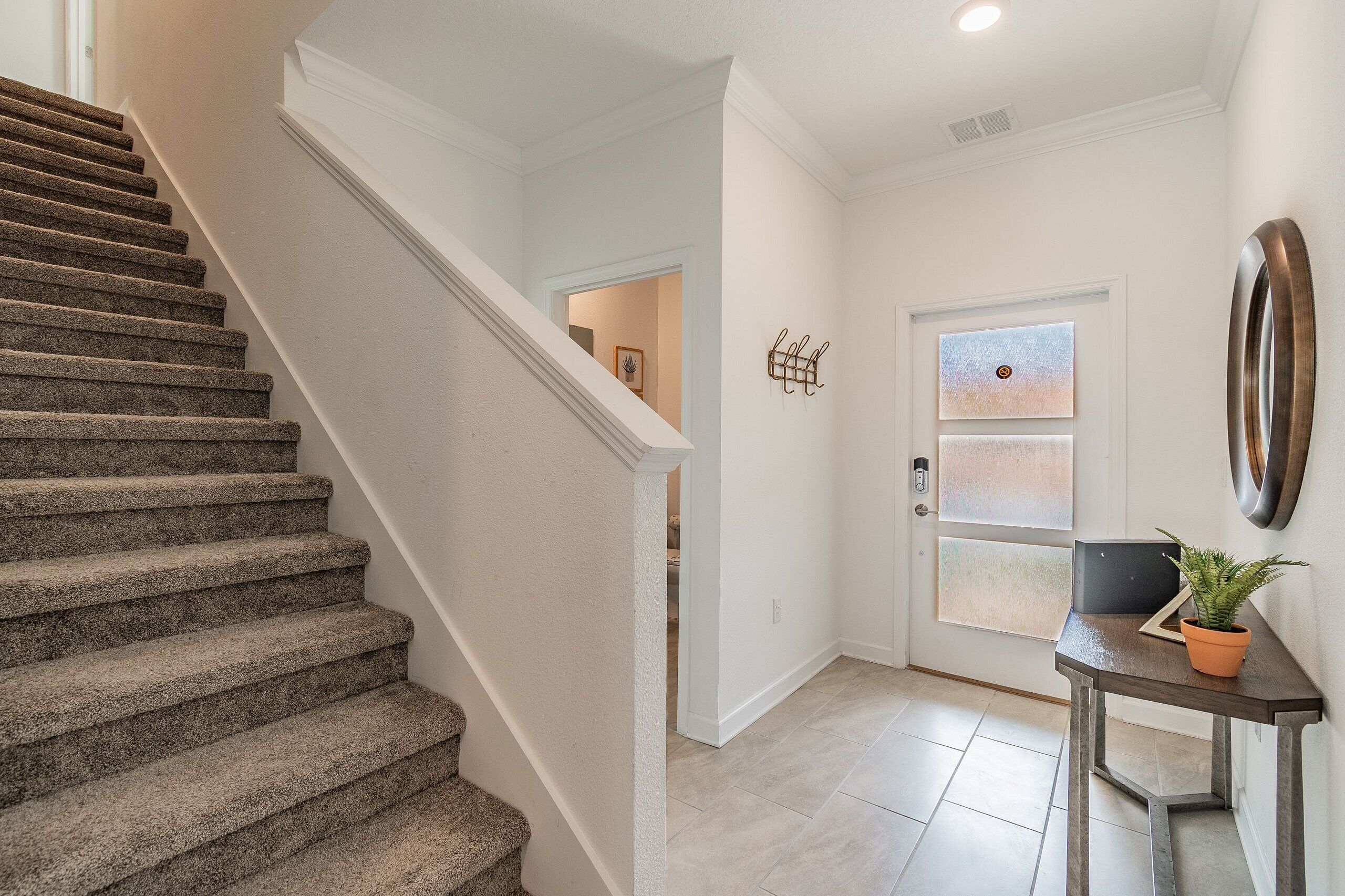 A staircase leading to a landing with a door and a small table with a plant.