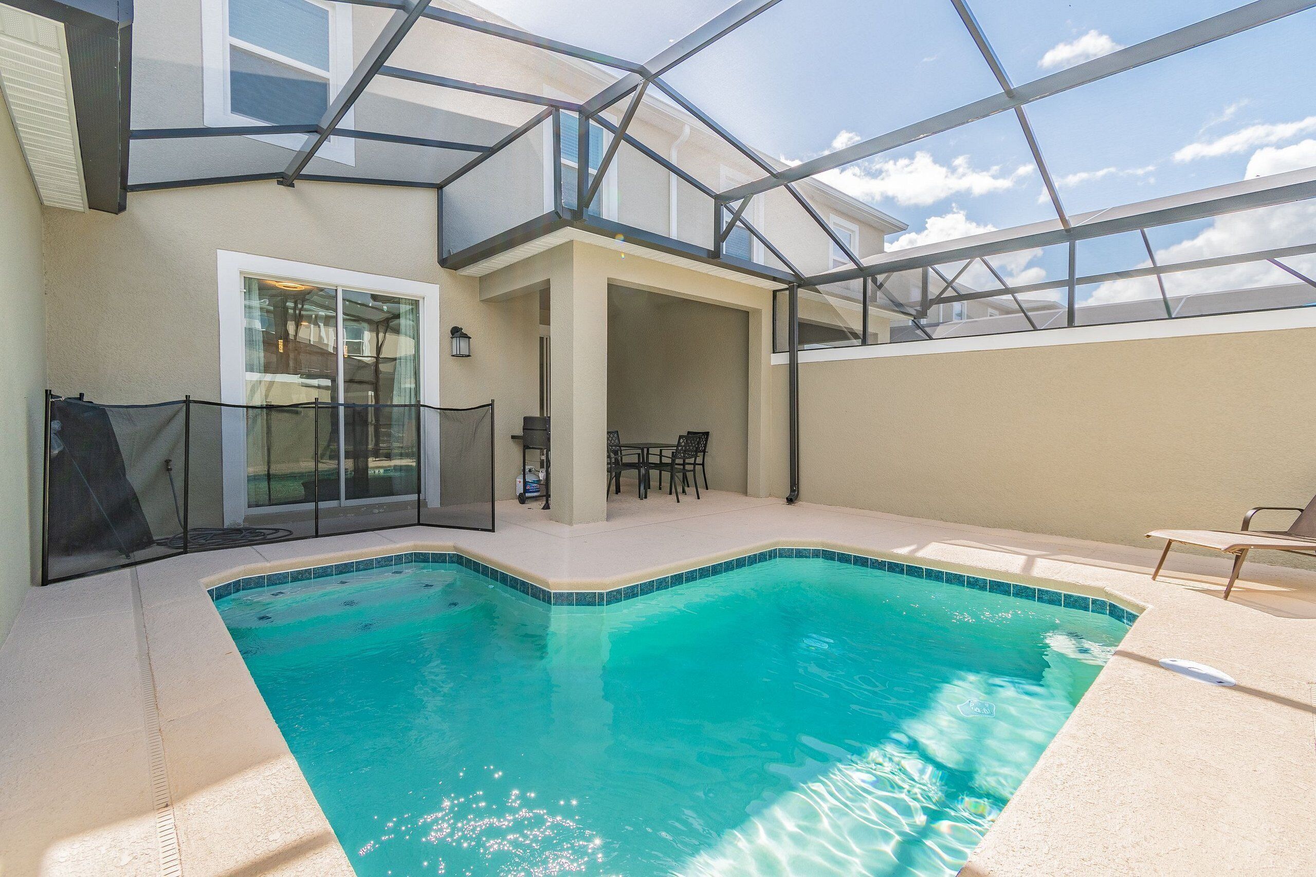 Una piscina con techo de vidrio, un patio cubierto y vista al cielo.