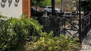 A building with a number '393' on the side, a covered outdoor seating area, and a parking lot in the background. - Depa con Jardín en la Americana | Lapso at Alarcón (Guadalajara)