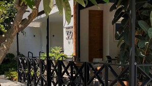 A covered outdoor area with a metal fence, a pathway, and a building with a door and a window. - Depa con Jardín en la Americana | Lapso at Alarcón (Guadalajara)