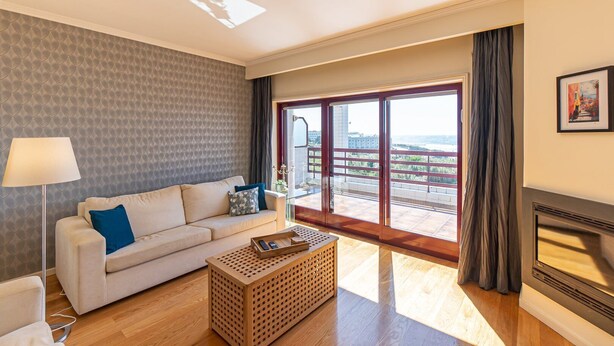 Een moderne woonkamer met een bank, een salontafel en een open haard.