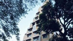 Un immeuble à plusieurs étages, doté d’une façade beige et de nombreuses fenêtres. On peut lire l’inscription « Shiv Om » sur le bâtiment.