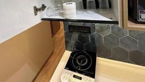 Una cocina compacta equipada con microondas, cafetera y una pequeña encimera.