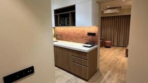 Una cocina moderna con encimera de madera, armarios empotrados y un equipo de aire acondicionado sobre la ventana.