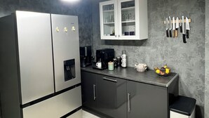 A modern kitchen with a refrigerator, coffee maker, and cabinets. - Penn-Ty: Cosy getaway in Brittany (Ploeren)