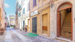Eine enge Straße mit Kopfsteinpflaster, ein Restaurant namens 'l'altra vineria' und eine Treppe, die zu einem Obergeschoss führt.