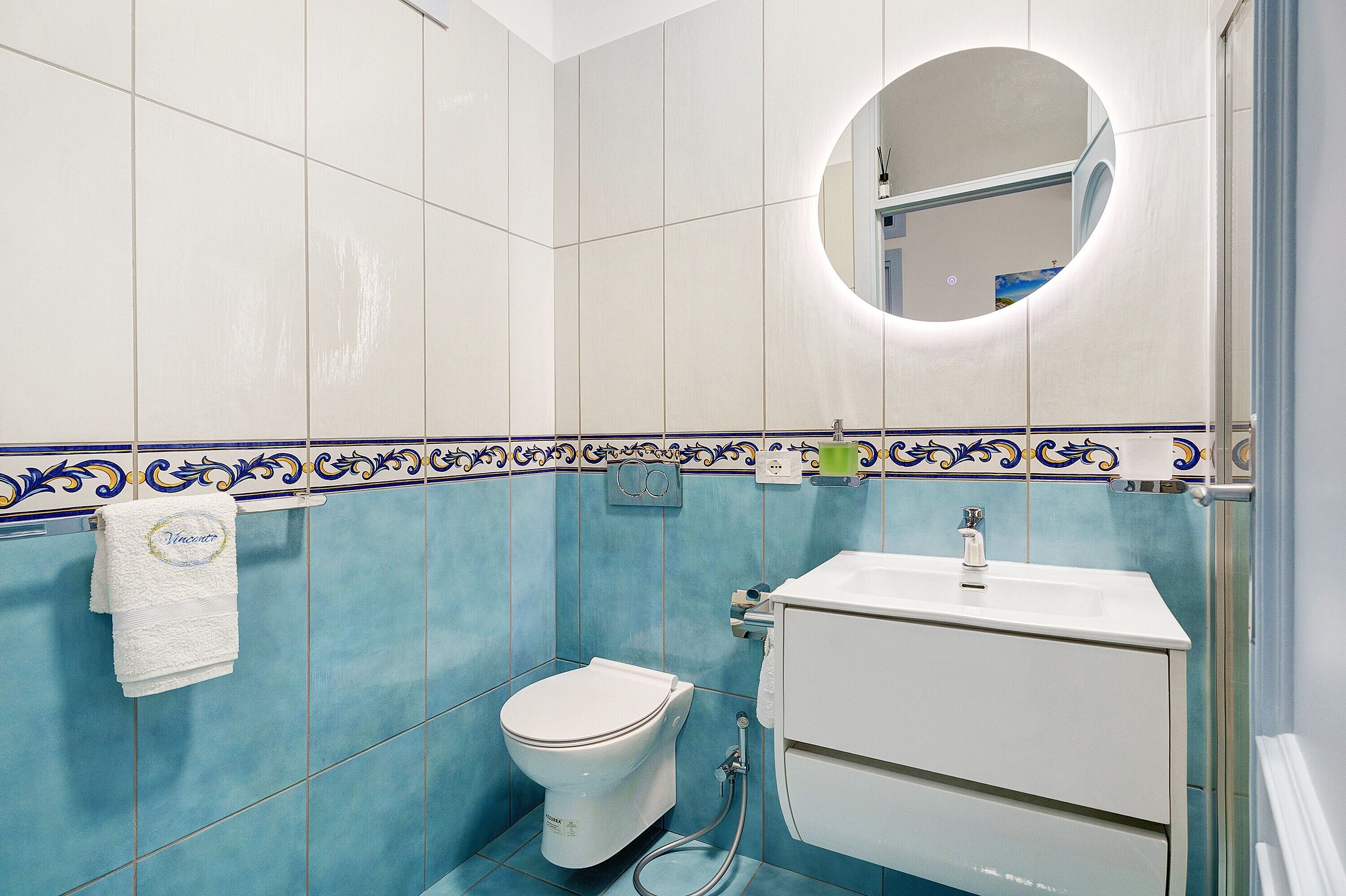 Une salle de bain avec des toilettes, un lavabo et un miroir.
