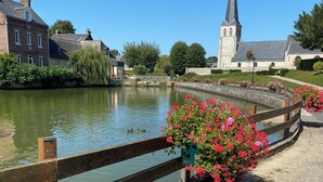 Un canal où nagent des canards, une église et un pont.