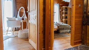 A wooden cabin interior with a bed, a vanity with a mirror, a chair, and a small table. - Guesthouse 'Chambre Granon Au Datcha' with Mountain View, Private Terrace and Wi-Fi (Briançon)