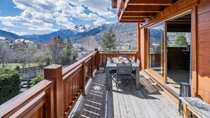 A wooden deck with a table and chairs, overlooking a mountainous landscape. - Guesthouse 'Chambre Granon Au Datcha' with Mountain View, Private Terrace and Wi-Fi (Briançon)
