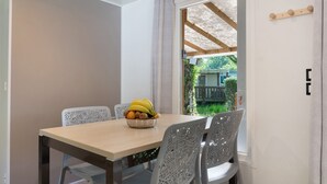 A dining area with a table, chairs, and a bowl of fruit.