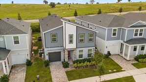 Un quartier résidentiel avec des maisons modernes à deux étages, une pelouse bien entretenue et un ciel dégagé.
