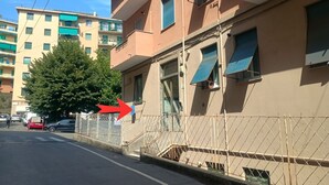 Un immeuble résidentiel à plusieurs étages, doté de balcons, d’une entrée sécurisée et surplombant un ciel dégagé.