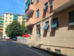 Un immeuble résidentiel à plusieurs étages, doté de balcons, d’une entrée sécurisée et surplombant un ciel dégagé.