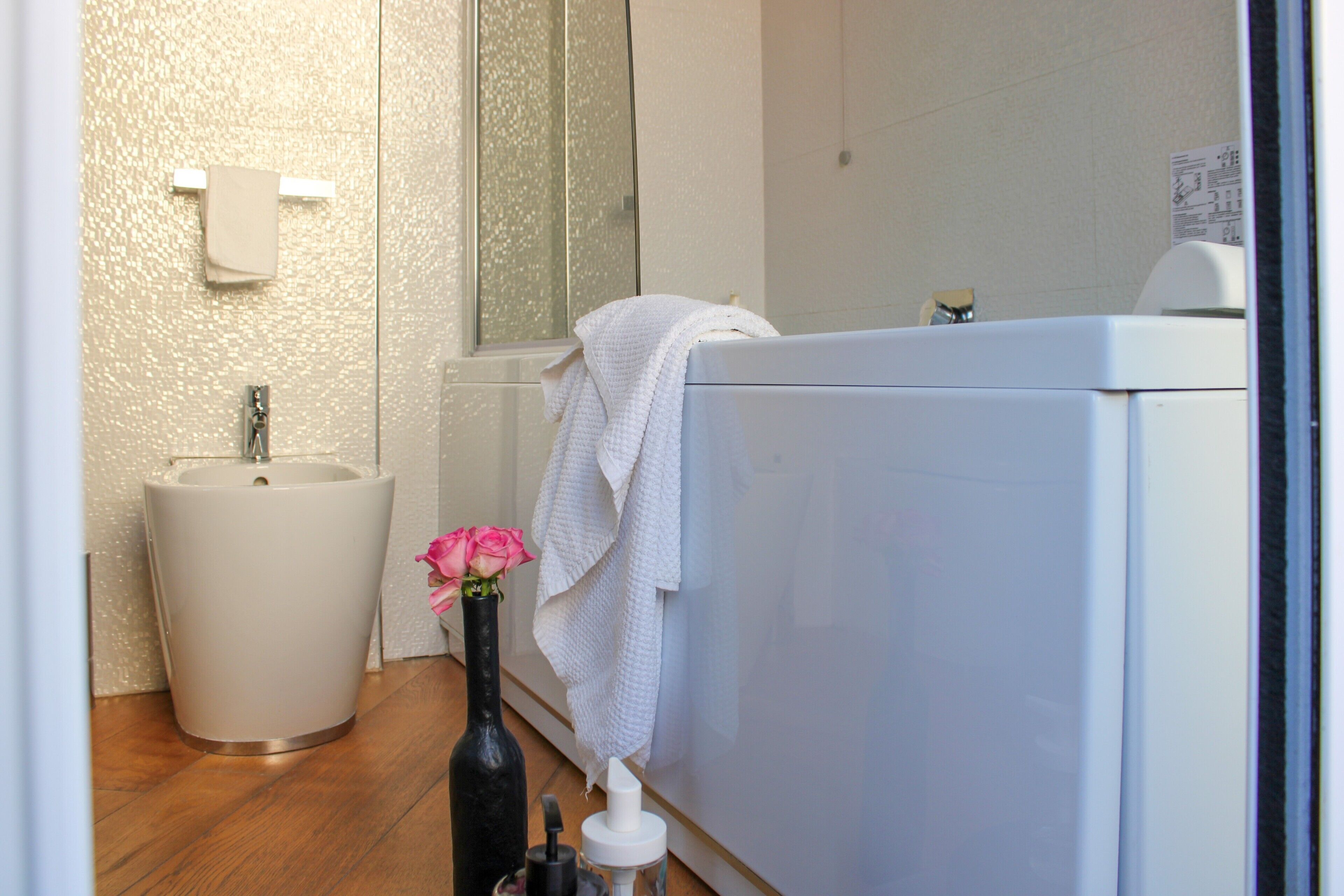 A bathroom with a sink, a bathtub, and a mirror.