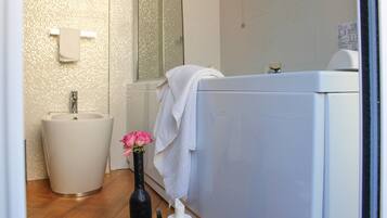 A bathroom with a sink, a bathtub, and a mirror.