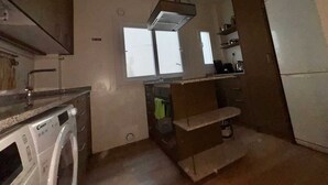 A kitchen with a built-in oven, a window, and a sink. - Rooms Carlos, next to Plaza Mayor (Madrid)