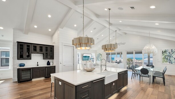 A spacious kitchen with dark cabinets, a large island, and pendant lighting. - Grayton Gold|Easy Beach Access|Private Pool|Golf Cart (Santa Rosa Beach)