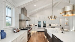 A modern kitchen with white cabinetry, stainless steel appliances, and a large island with a sink. - Grayton Gold|Easy Beach Access|Private Pool|Golf Cart (Santa Rosa Beach)