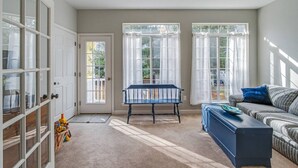 Un salon spacieux avec une grande fenêtre, un banc, un canapé et un meuble.