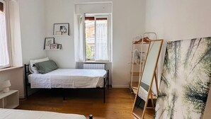 A minimalist bedroom with a bed, a small bedside table, a hanging light fixture, a window with a view, and a painting on the wall. - Emilù Guest House In the center of Pescara 300 m. from the sea Entire apartment. (Pescara)