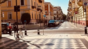 A checkered pedestrian area with buildings on either side, a bicycle, and a few pedestrians. - Emilù Guest House In the center of Pescara 300 m. from the sea Entire apartment. (Pescara)