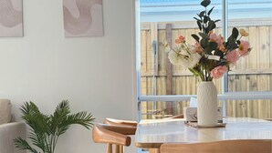Ein Essbereich mit Holztisch, Stühlen und einer Blumenvase.