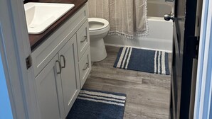 Une salle de bain avec des toilettes, un lavabo et une baignoire.