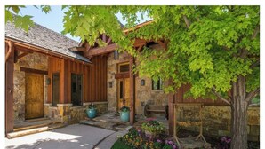 A stone building with wooden doors and a covered porch. - Luxury House in Gated Community (Carbondale)