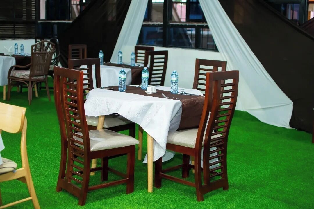 A dining area with a table set for four, surrounded by wooden chairs with cushioned seats.