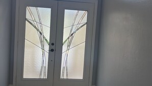 A door with frosted glass panels and a view of the sky through an archway.