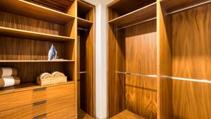 Ein begehbarer Kleiderschrank mit Holzböden und Schubladen, ausgestattet mit einer Stange zum Aufhängen von Kleidungsstücken.
