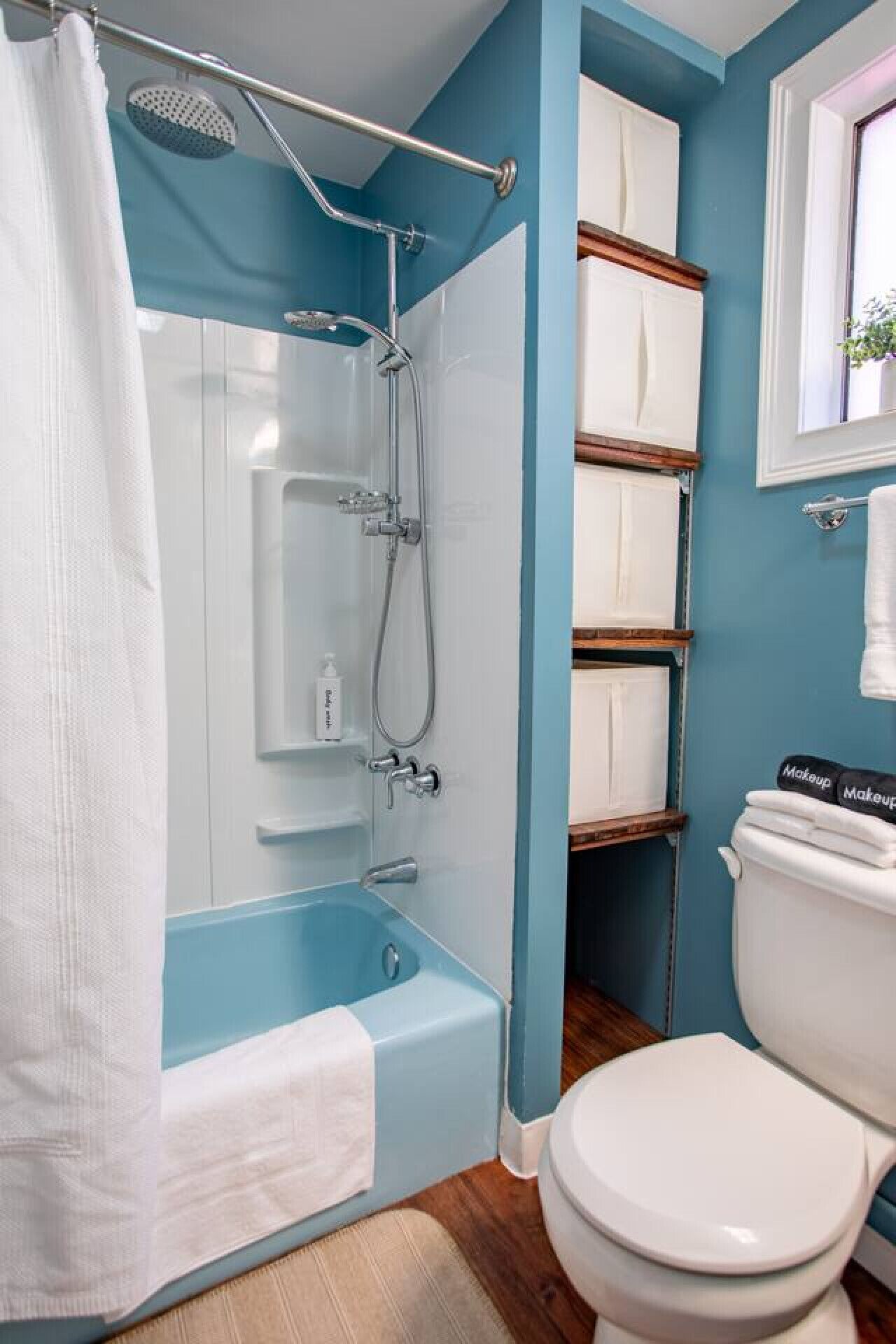 Un baño con ducha, inodoro y repisas.