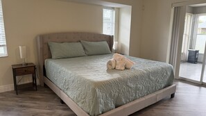 A bedroom with a bed, a bedside table, and a window.