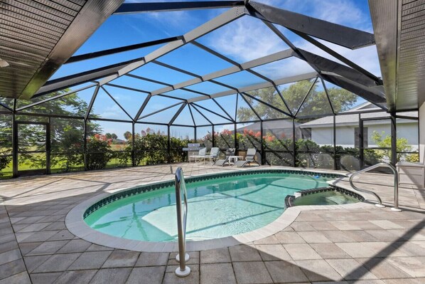 Une piscine extérieure couverte, dotée d’un espace patio, d’un jacuzzi et offrant une vue sur le paysage environnant.