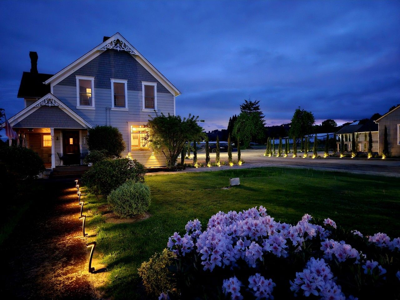 A two-story house with a well-maintained lawn and a pathway leading to the entrance.