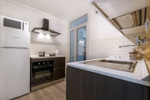 A modern kitchen with a built-in oven, microwave, and stainless steel sink.