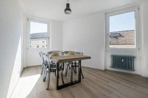 Comedor con mesa, sillas y lámpara colgante.
