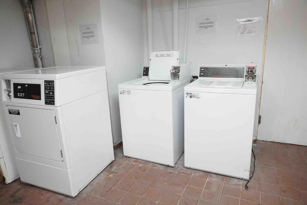 A laundry room with three stacked washers and dryers.