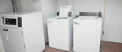 A laundry room with three stacked washers and dryers.