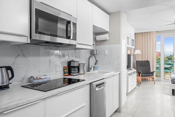 A modern kitchen with a built-in microwave, coffee maker, and dishwasher.