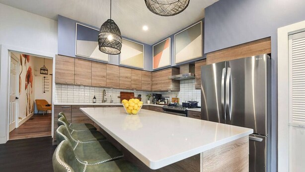 Una cucina moderna con una grande isola, elettrodomestici in acciaio inossidabile e un design minimalista.