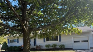A single-story house with a garage, a tree in front, and a well-maintained lawn. - Charming 2-bedroom + office house, safe, quiet, and convenient (Rochester)