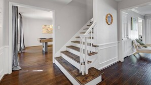 Un escalier avec des rampes blanches et des marches en bois menant à un palier.