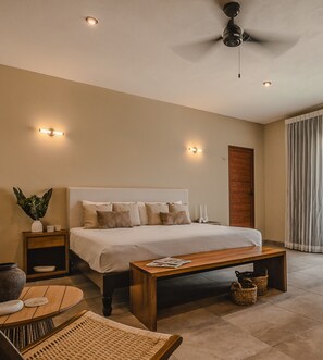 A bedroom with a bed, bedside tables, a ceiling fan, and a window with curtains.