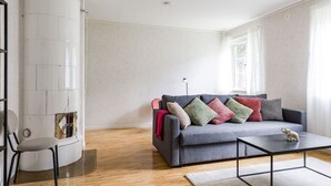 Un salon moderne avec un canapé gris, une table basse et une cheminée.