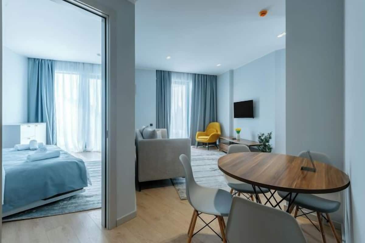 Une chambre d’hôtel moderne équipée d’un lit, d’un canapé, d’une table à manger et d’un téléviseur.