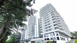 A modern high-rise building with multiple balconies and large windows. - Mziuri Gardens Apartments (Makhinjauri)