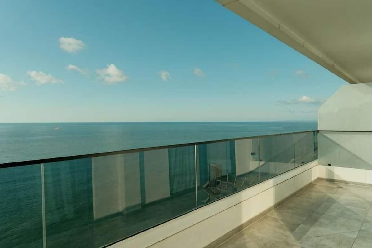 Un balcon doté d’une balustrade en verre donnant sur la mer.